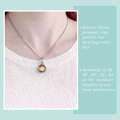 Model wearing Citrine gemstone spinner necklace and pale pink jumper.