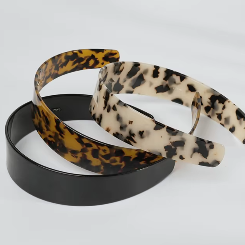 Three hairbands with leopard print, black, and beige patterns on a white background