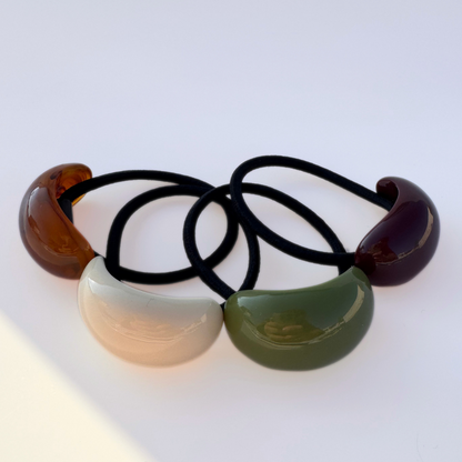 Set of four hair ties with colorful plastic ends on a white background