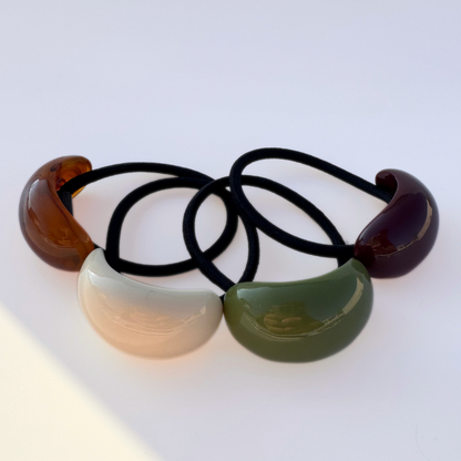 Set of four hair ties with colorful plastic ends on a white background