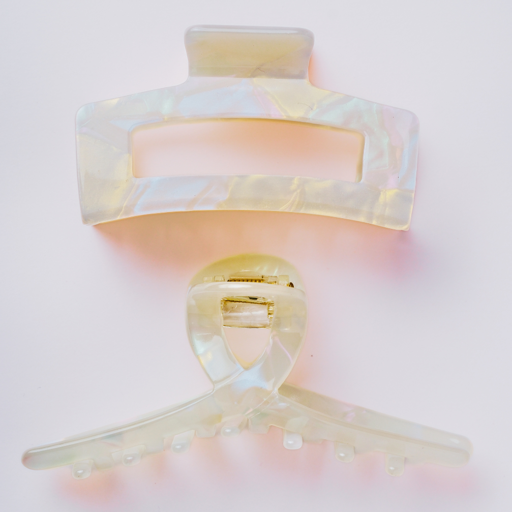 Hair clips with a soft pink and gold gradient on a light pink background