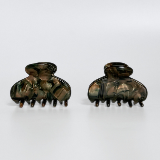 Pair of dark hair clamps on a white background