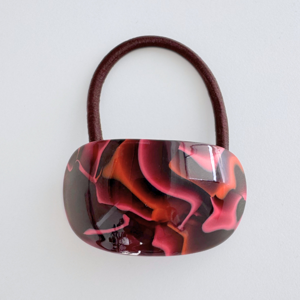 Marbled pink and red hair tie on a white background