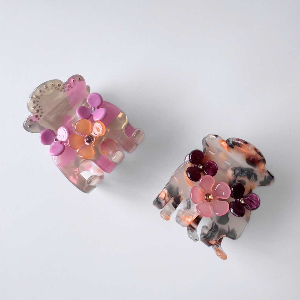 Pair of floral hair clips with tortoiseshell design on a white background