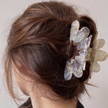 Person with decorative hair clips in their bun against a neutral background