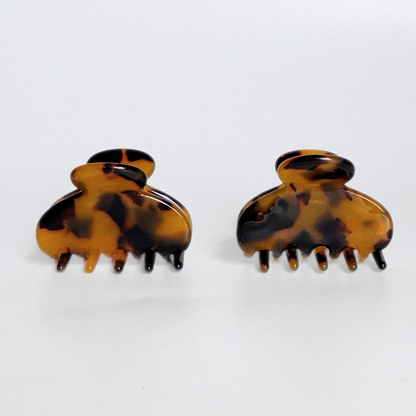 Pair of tortoiseshell hair clamps on a white background