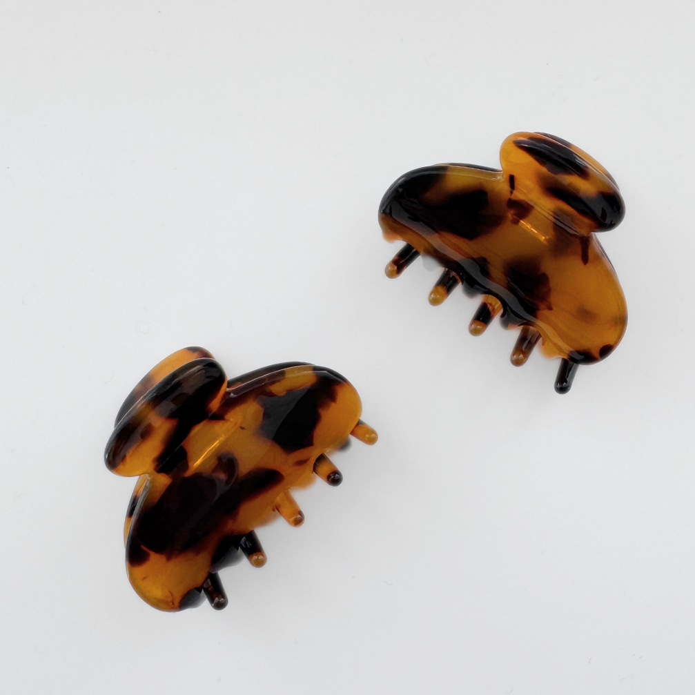 Pair of tortoiseshell hair clips on a white background