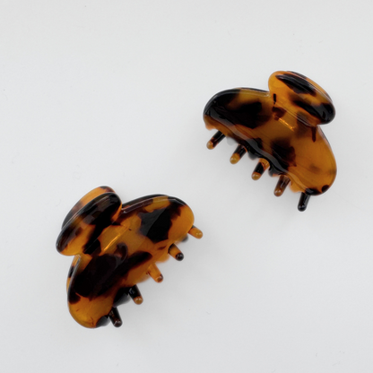 Pair of tortoiseshell hair clips on a white background