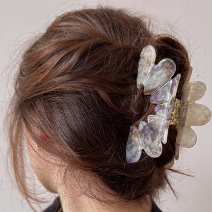 Person with decorative hair clips in their bun against a neutral background