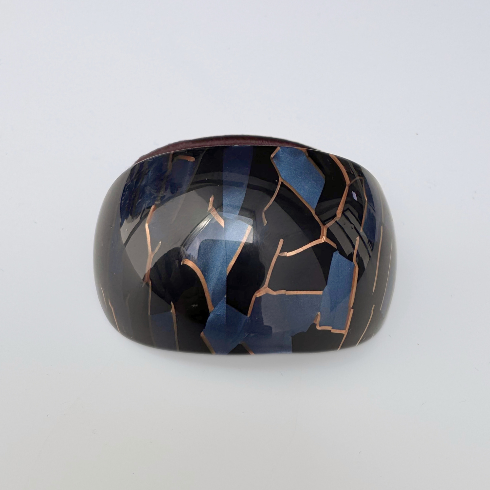 Black and blue hair tie with a cracked design on a white background