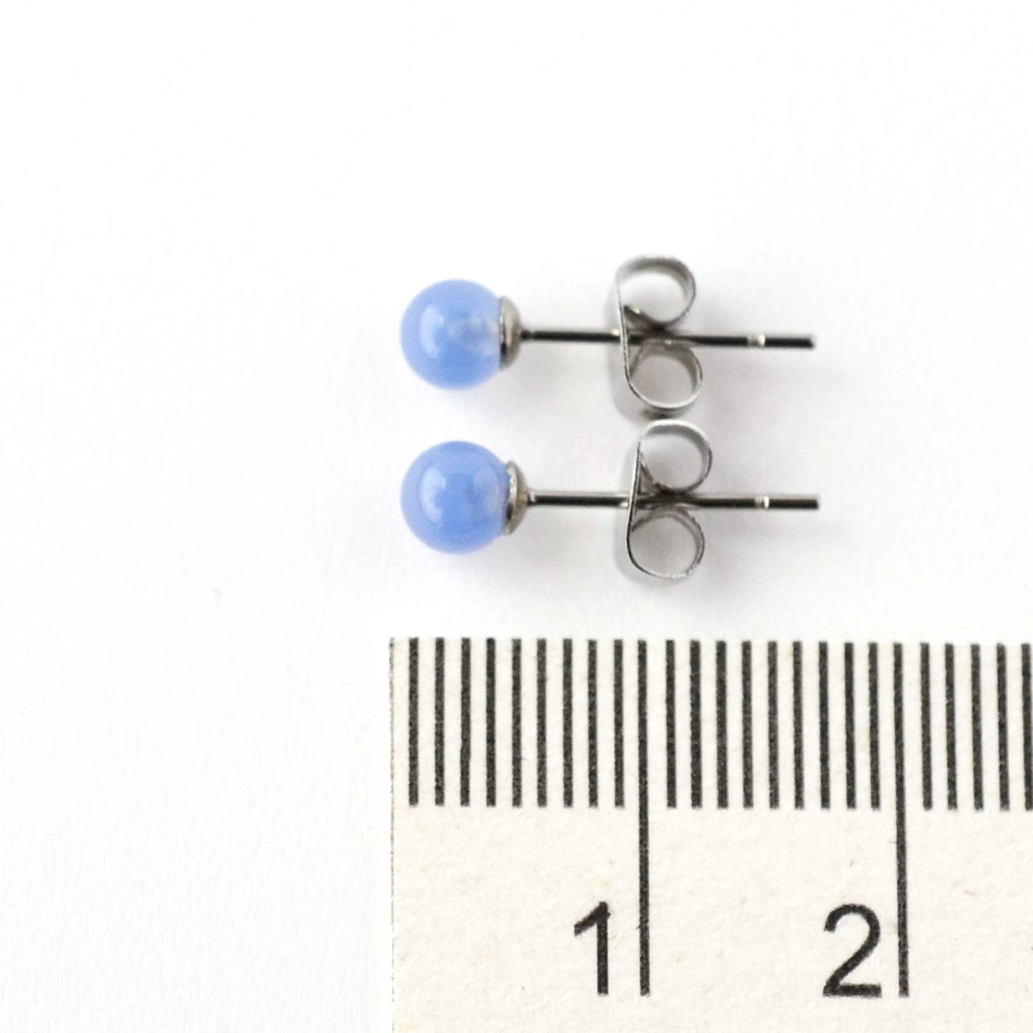 4mm Blue Onyx gemstone stud earrings next to ruler