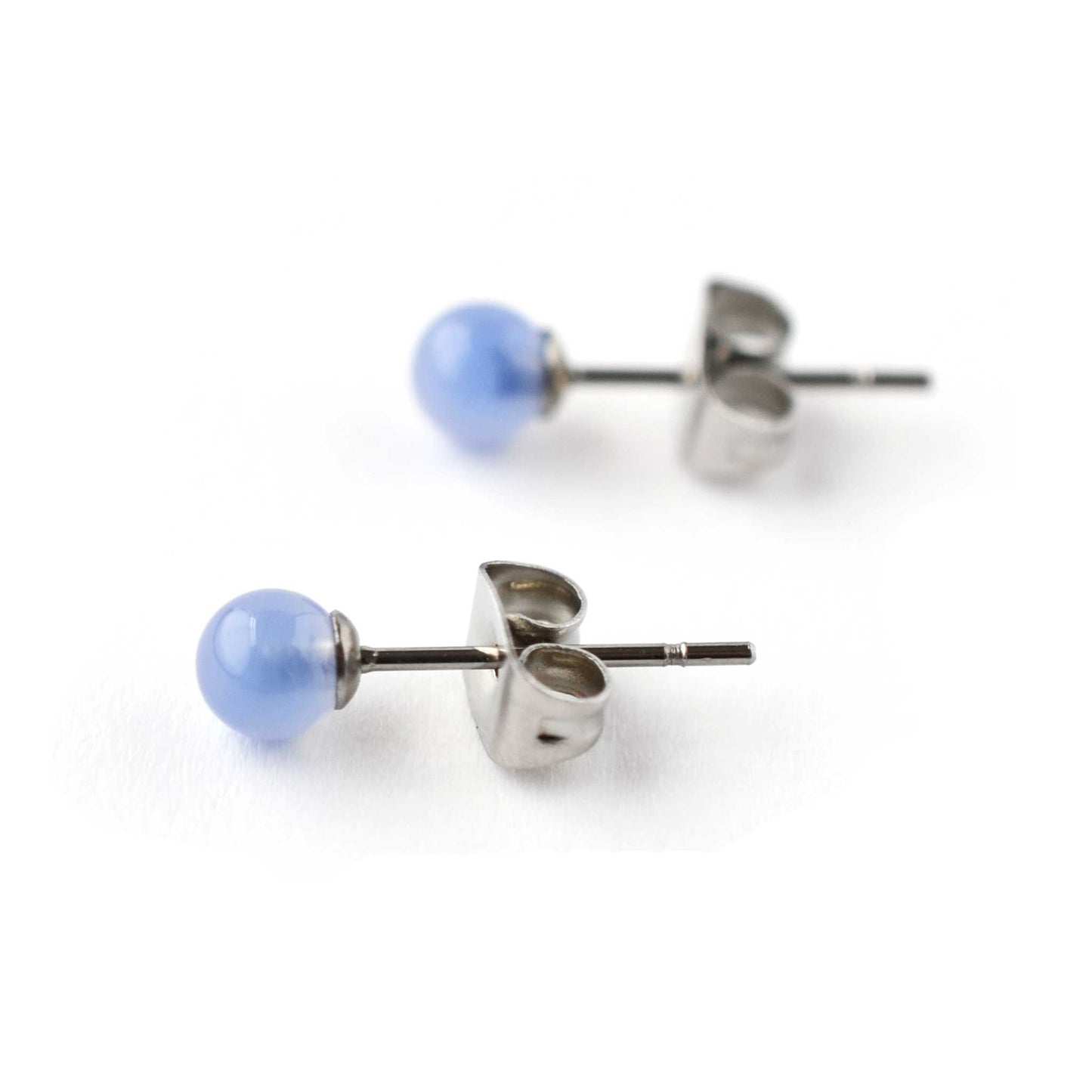 Close up of 4mm Blue Onyx gemstone ball stud earrings on white background