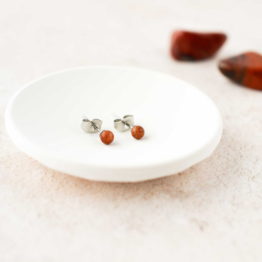 Dainty 4mm Goldstone gemstone ball stud earrings in trinket dish