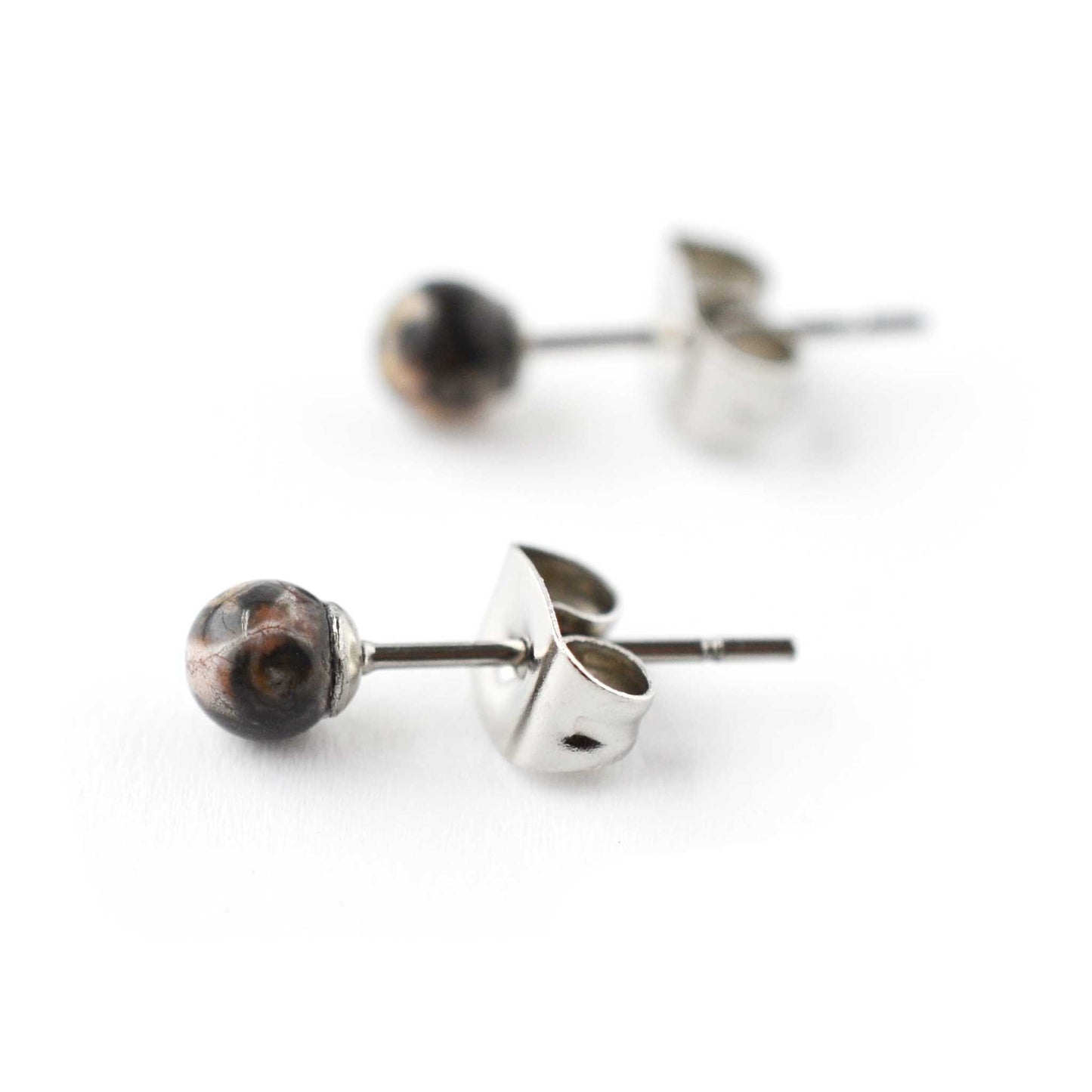 Close up of Jasper and surgical steel gemstone ball stud earrings on white background