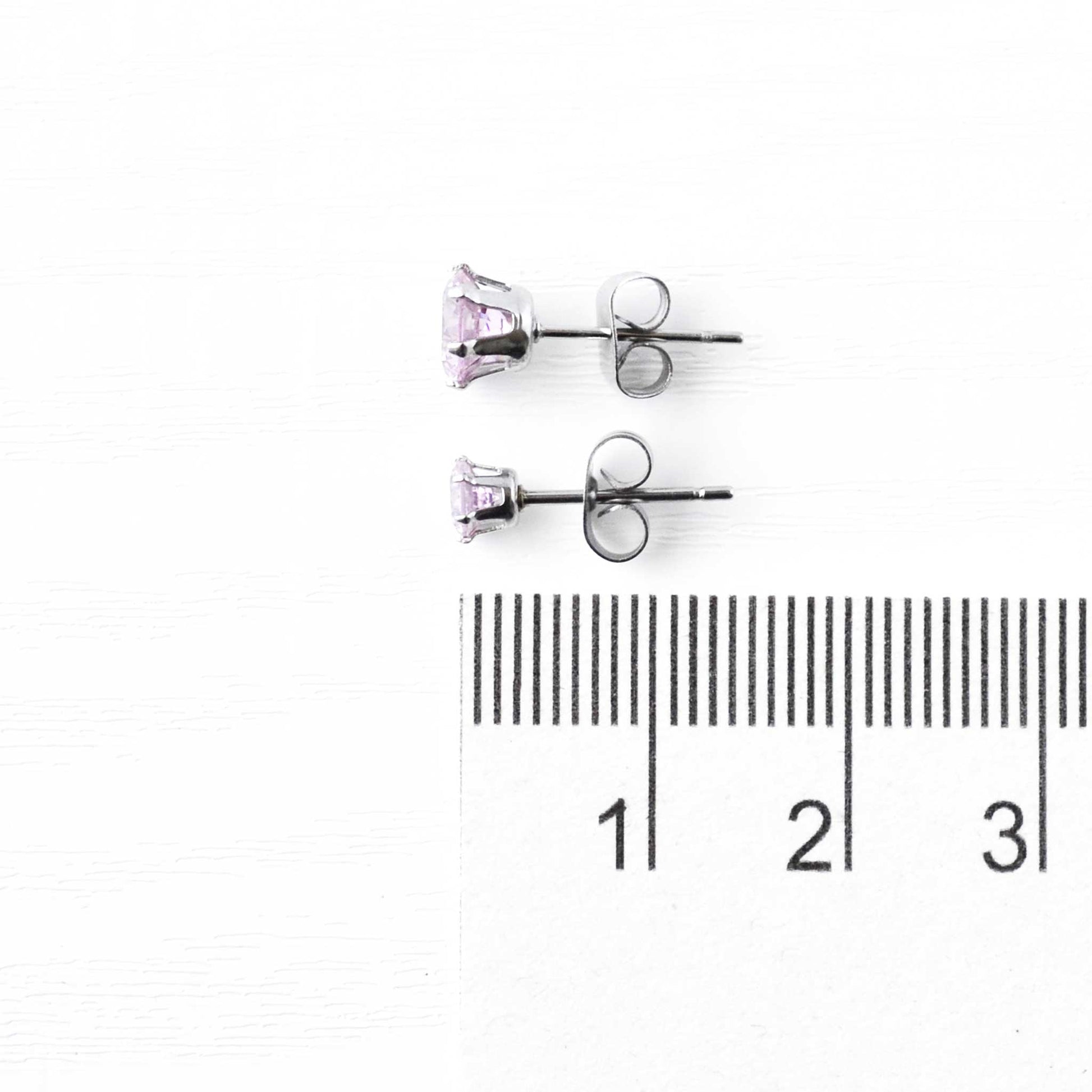 4mm & 6mm pink Cubic Zirconia stud earrings next to ruler