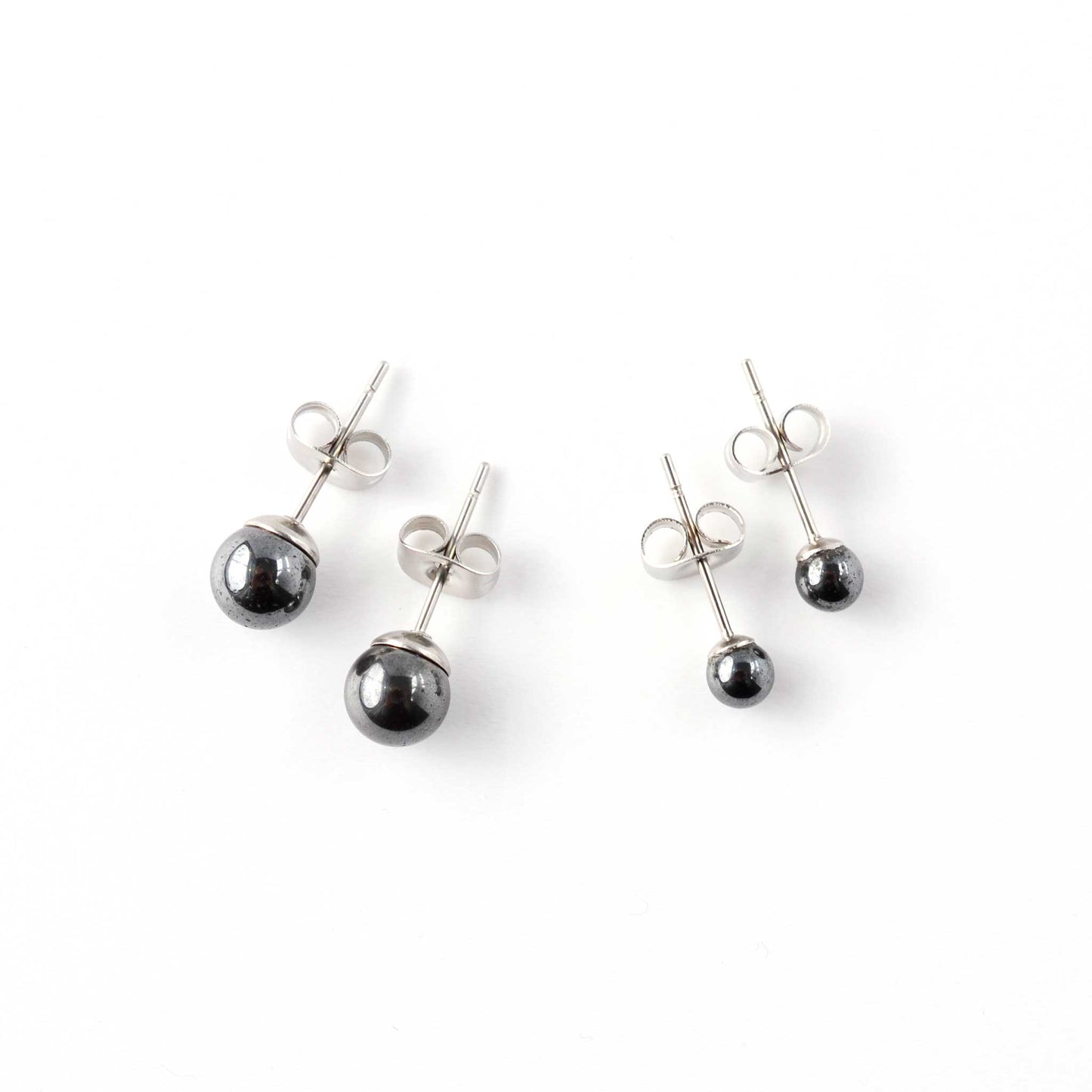 Small and large Hematite stud earrings laying on white background.