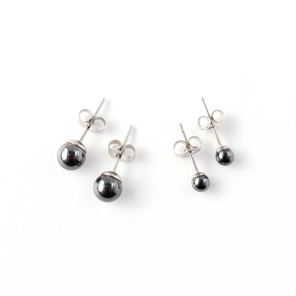 Small and large Hematite stud earrings laying on white background.