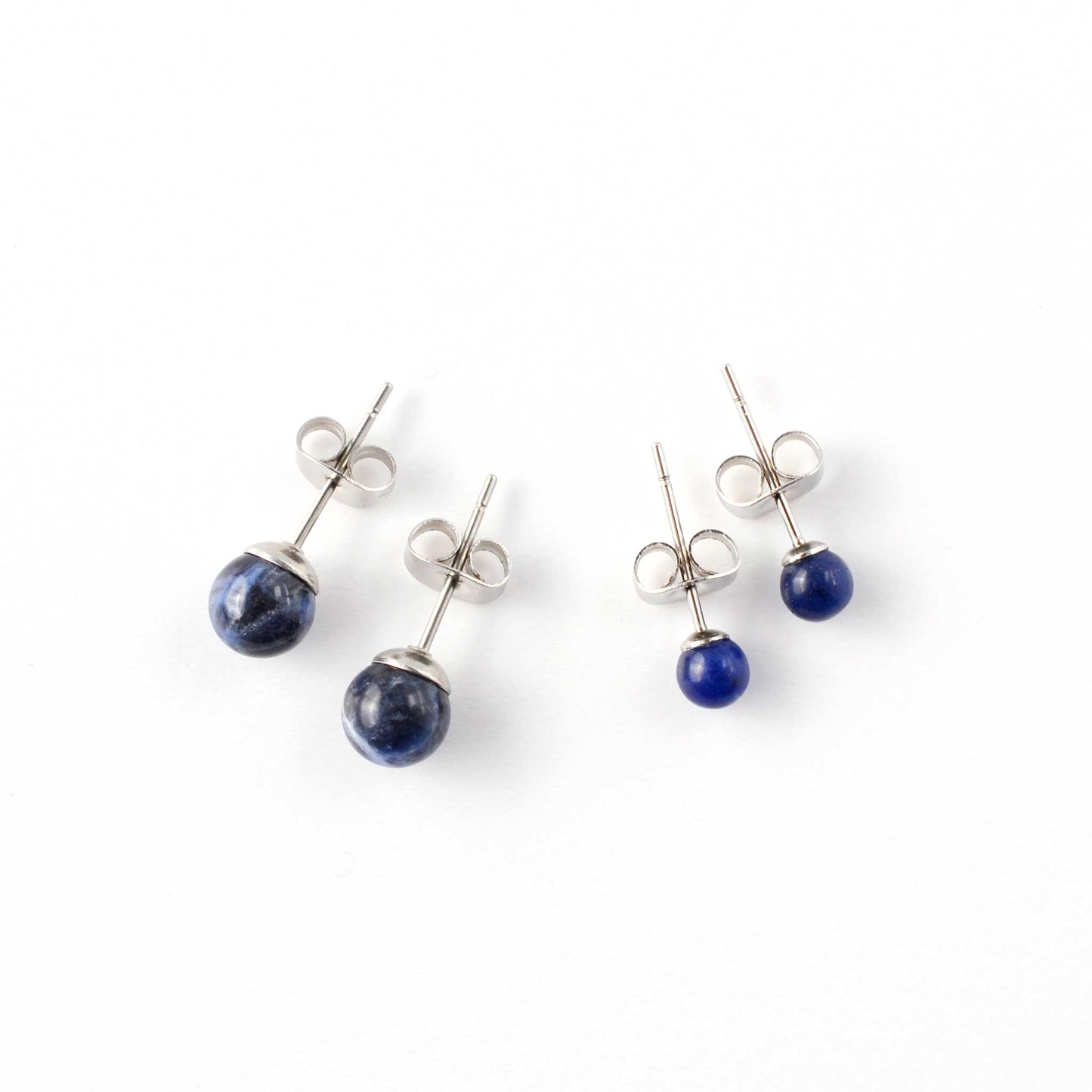 Small and large Sodalite stud earrings laying on white background.