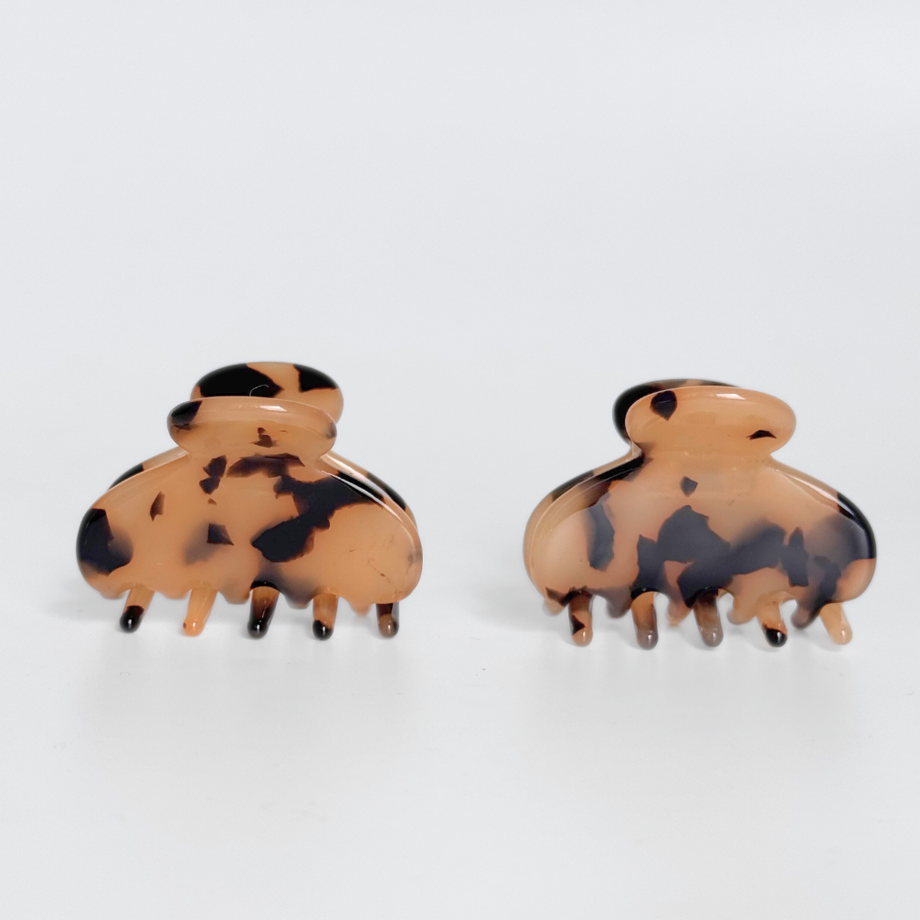 Pair of tortoiseshell hair clips on a white background