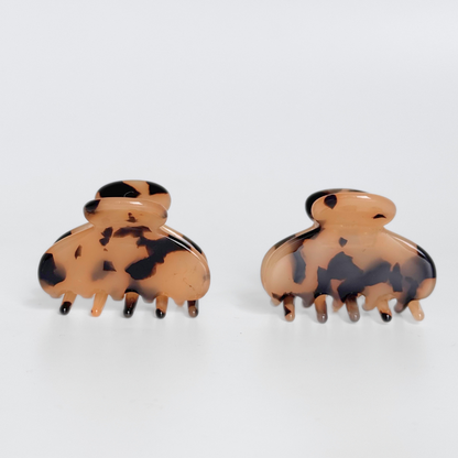 Pair of tortoiseshell hair clips on a white background