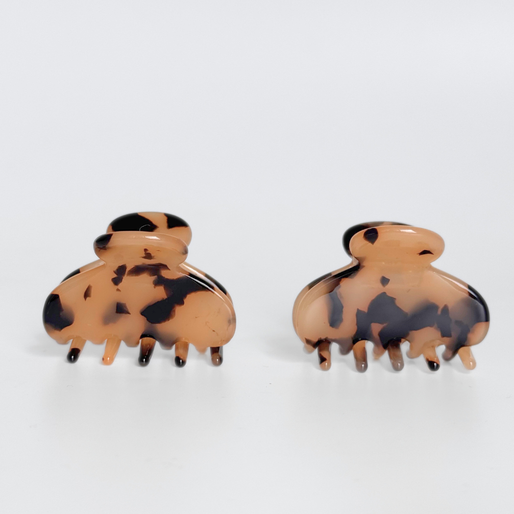 Pair of tortoiseshell hair clips on a white background