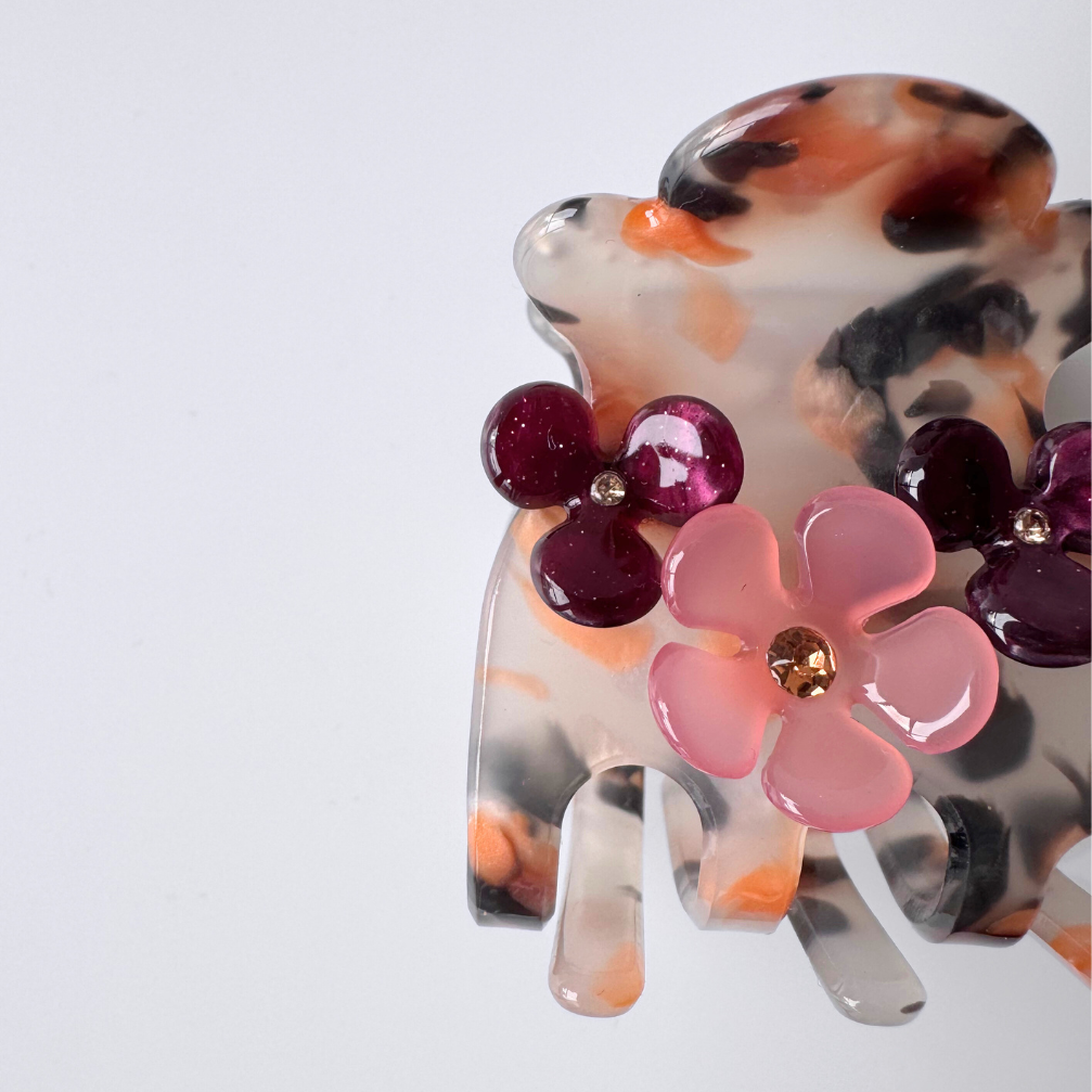 Decorative hair clip with floral design on a white background