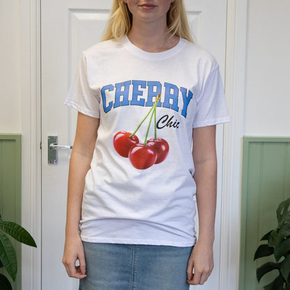 Person wearing a white t-shirt with 'Cherry' design and text in a room with plants.