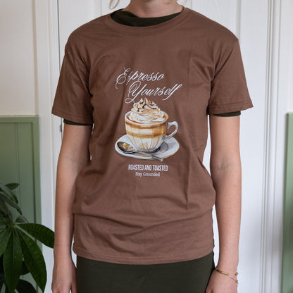 Person wearing a brown t-shirt with a coffee-themed graphic and text.
