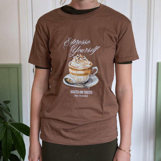 Person wearing a brown t-shirt with a coffee-themed graphic and text.