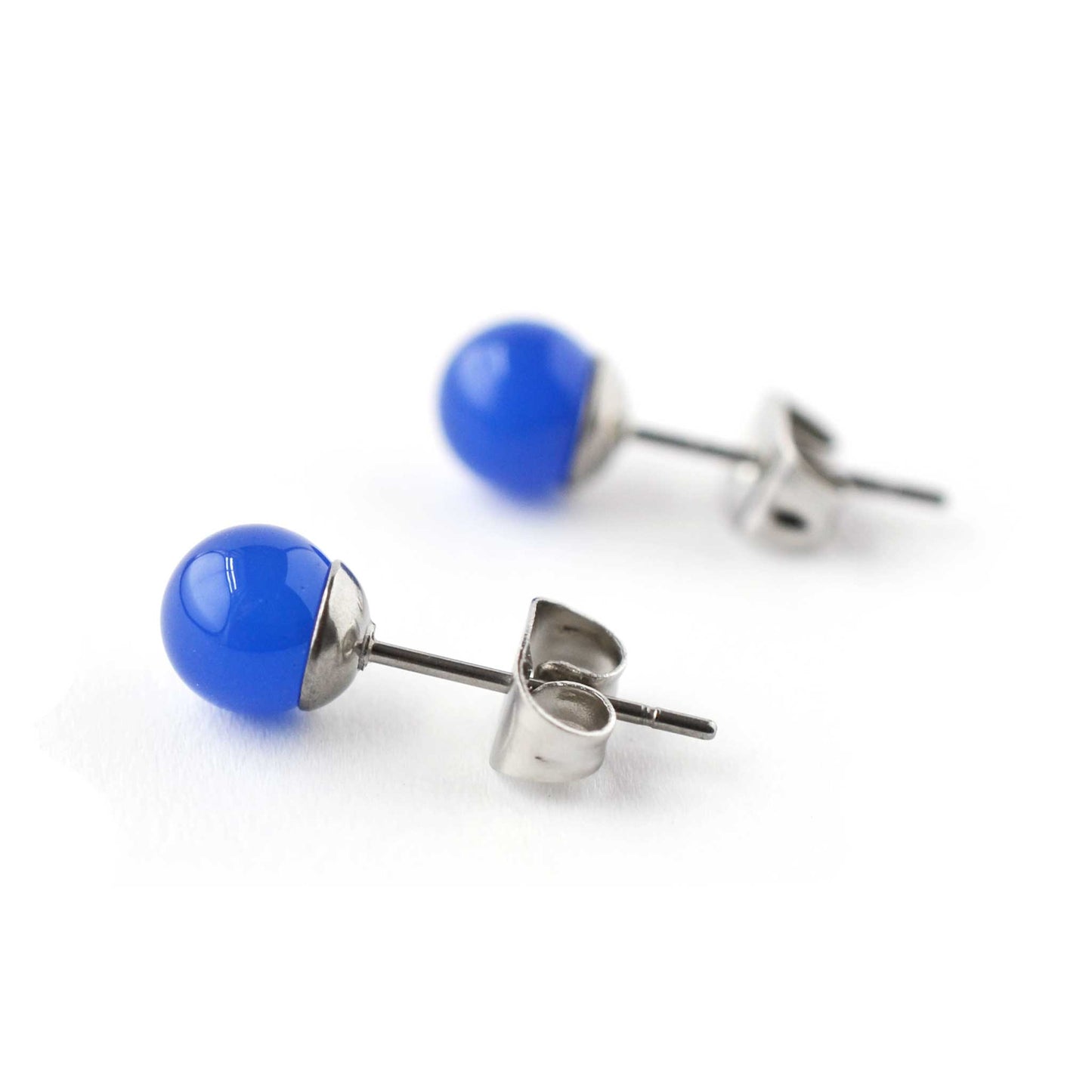 Close up of 6mm Blue Onyx & surgical steel stud earrings on white background