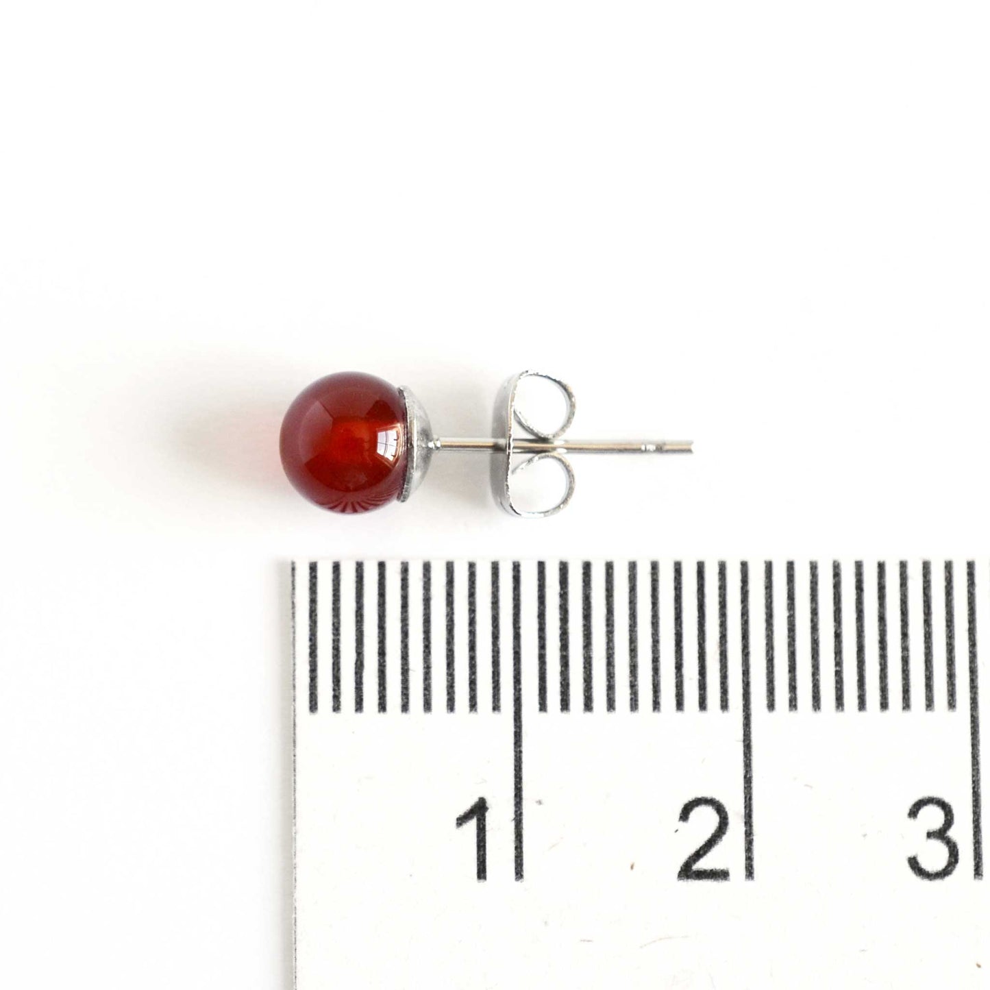 6mm Carnelian gemstone ball stud earring next to ruler