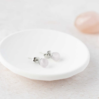 Rose Quartz gemstone ball stud earrings laying in white trinket dish.