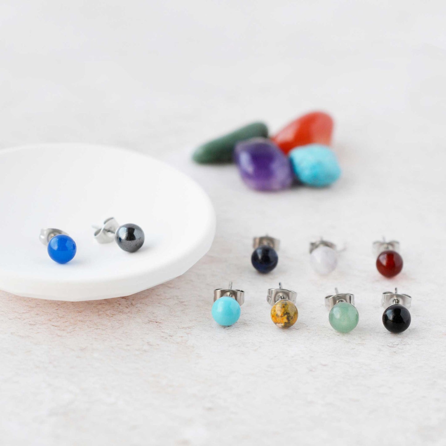 Small gemstone ball stud earrings displayed next to trinket dish.