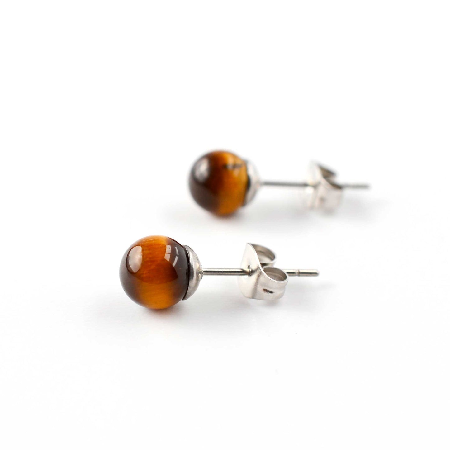 Side view of Tigers Eye round gemstone earrings on white background.