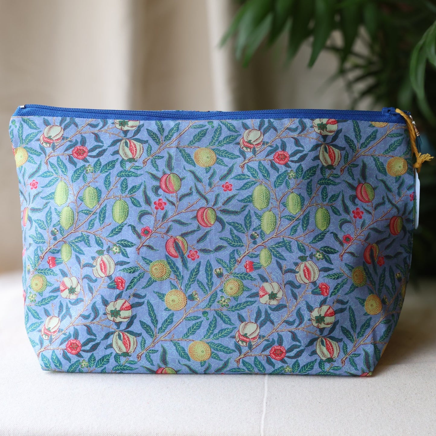 Blue pouch with floral pattern on a white surface
