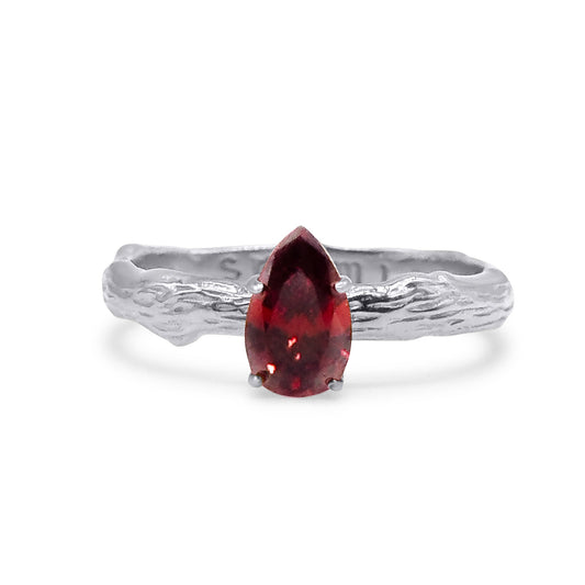 Stainless steel ring with a red gemstone on a white background