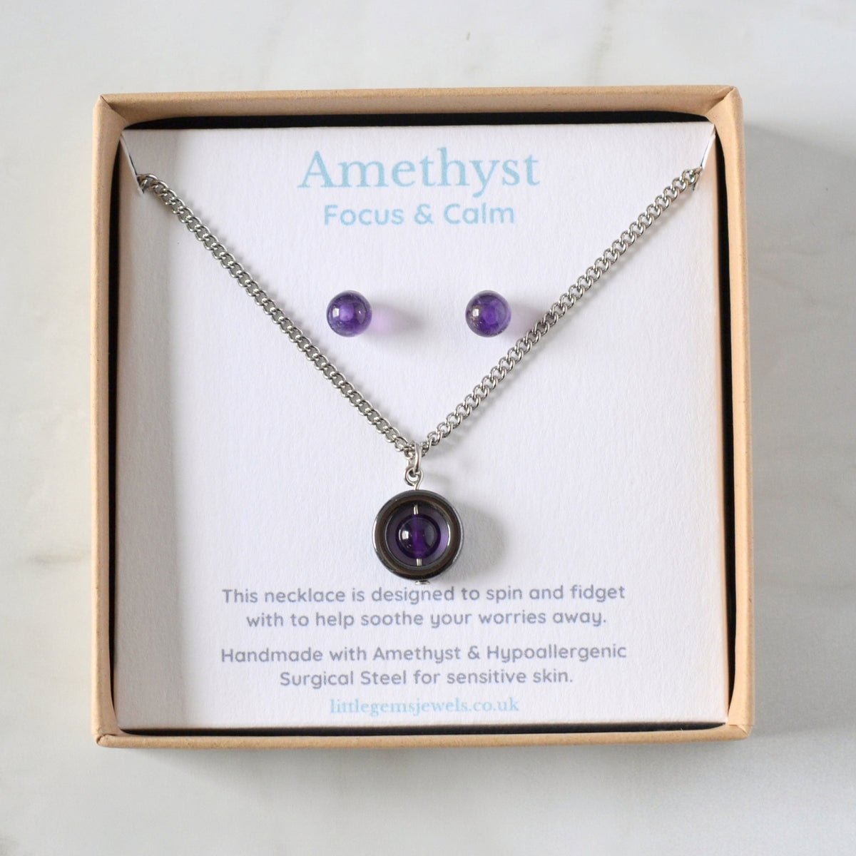 Amethyst gemstone spinner necklace and matching stud earring set in an eco friendly gift box.