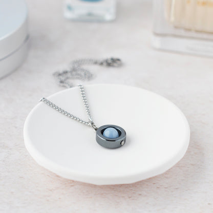 Angelite spinner necklace laying in white trinket dish.