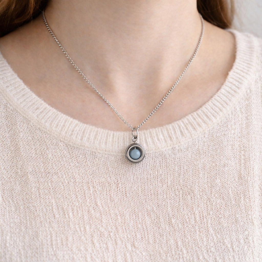 Model wearing pale pink jumper and dainty blue Angelite gemstone spinner necklace.
