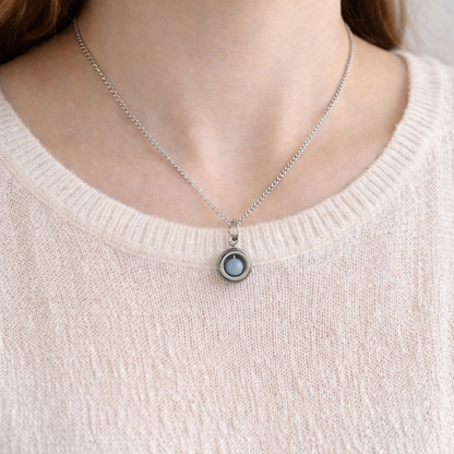 Model wearing pale pink jumper and dainty blue Angelite gemstone spinner necklace.