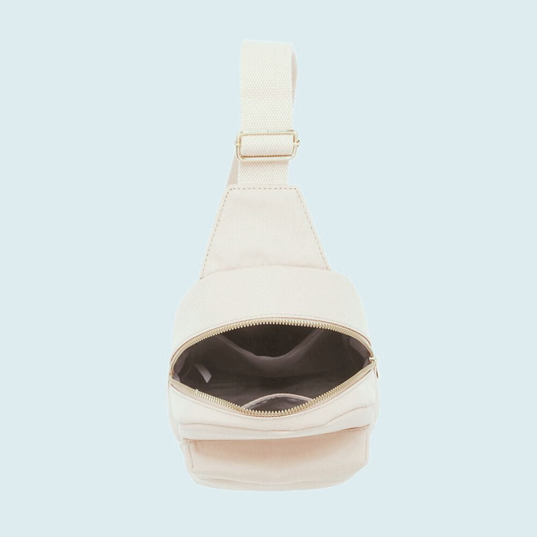 Open top of beige sling bag on a light blue background