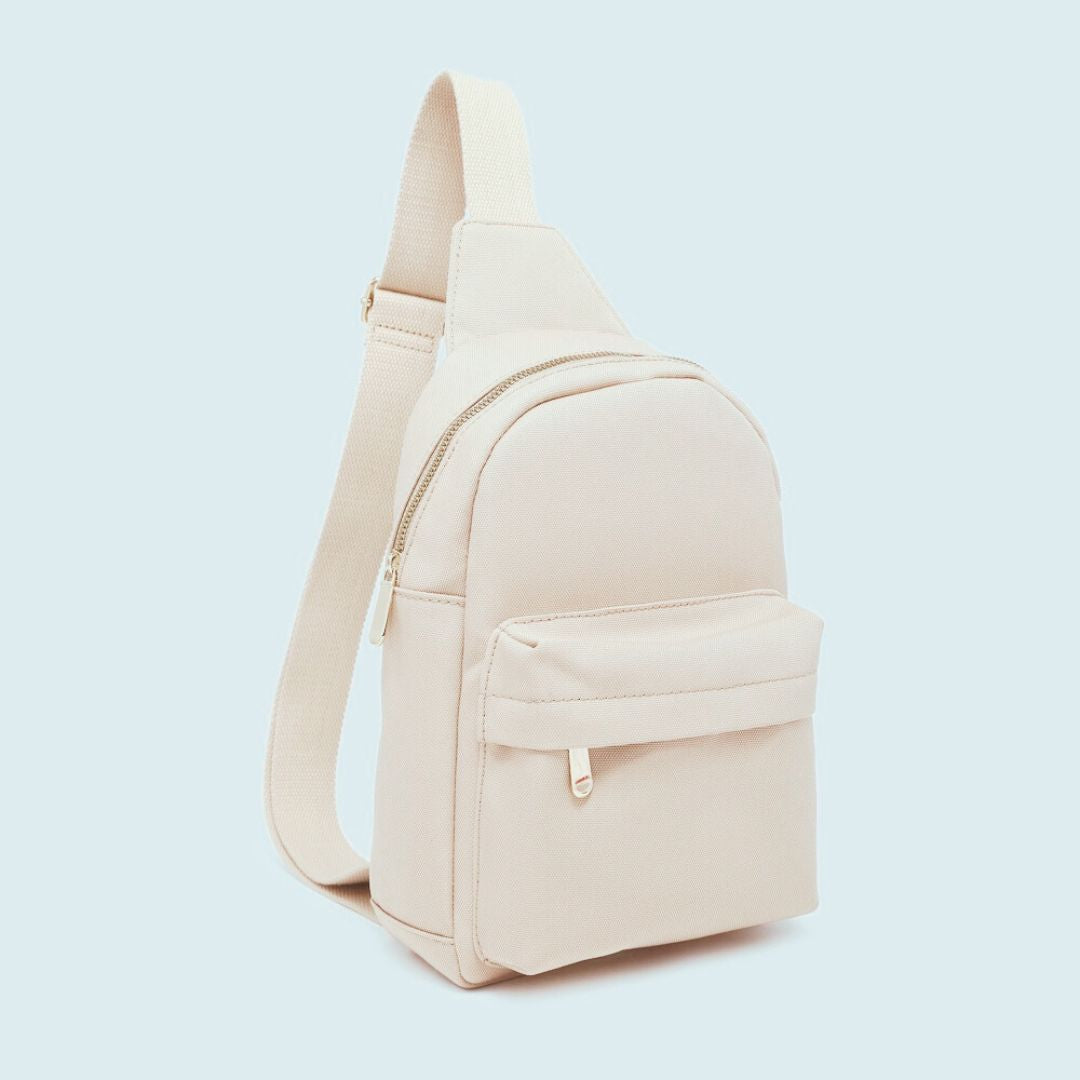 Beige sling bag on a light blue background