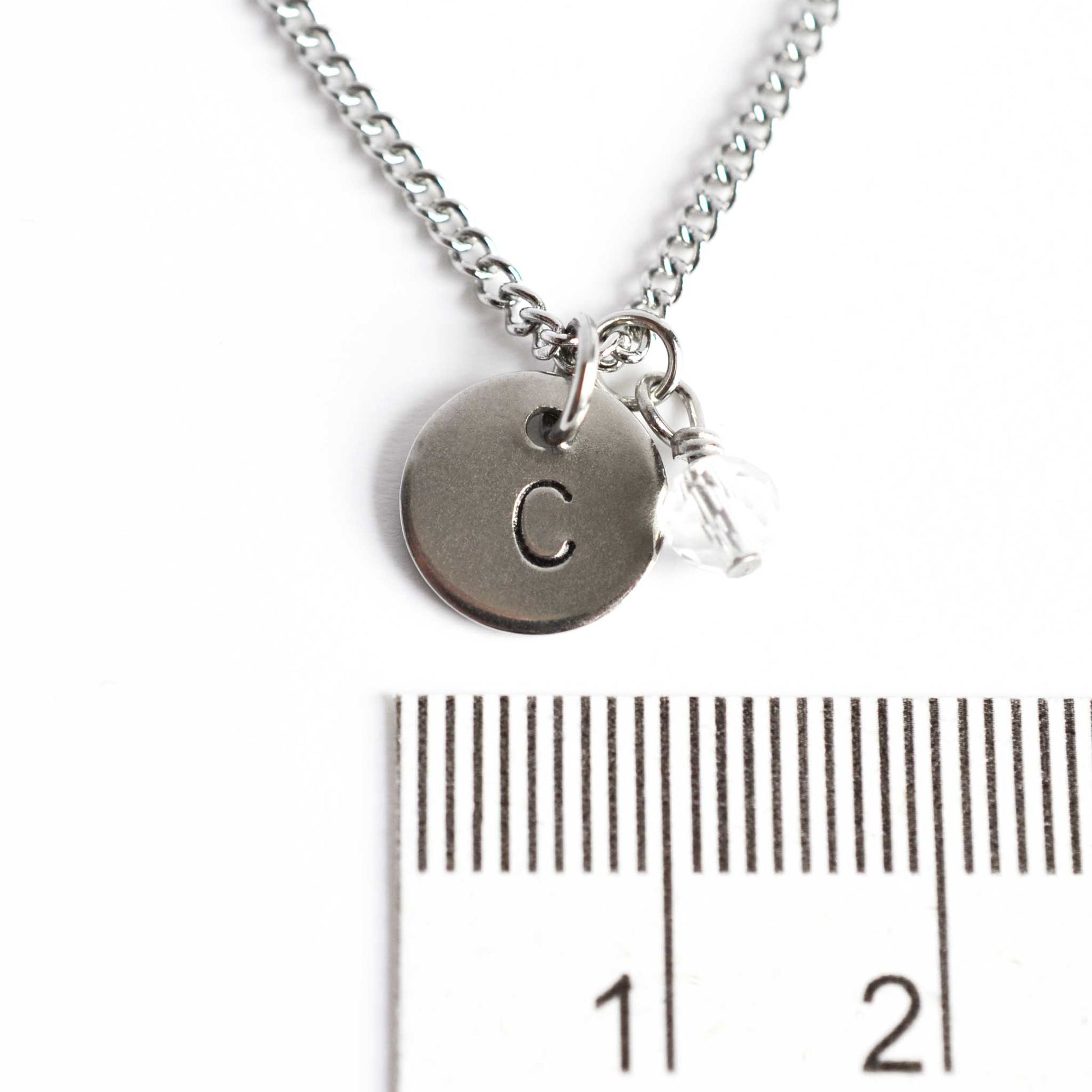 1cm diameter hand stamped disc pendant with 4mm April birthstone charm