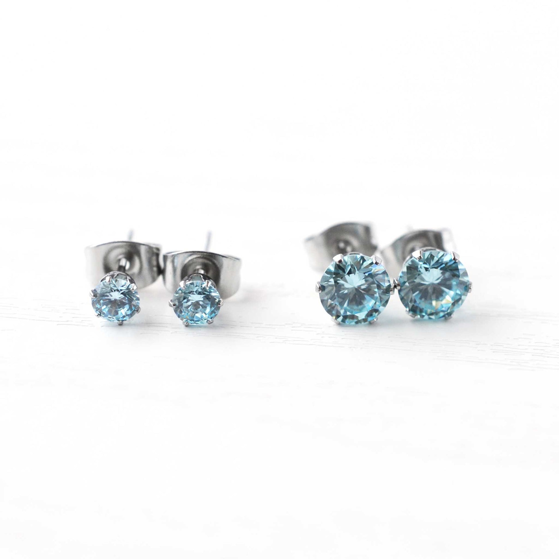 4mm & 6mm Aqua Blue CZ Stud Earrings On White Background.