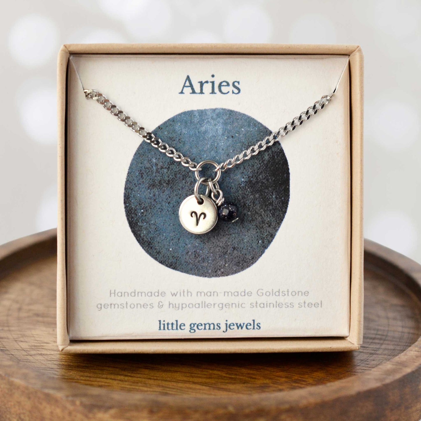 Dainty Aries zodiac sign necklace in eco-friendly gift box on wooden coaster