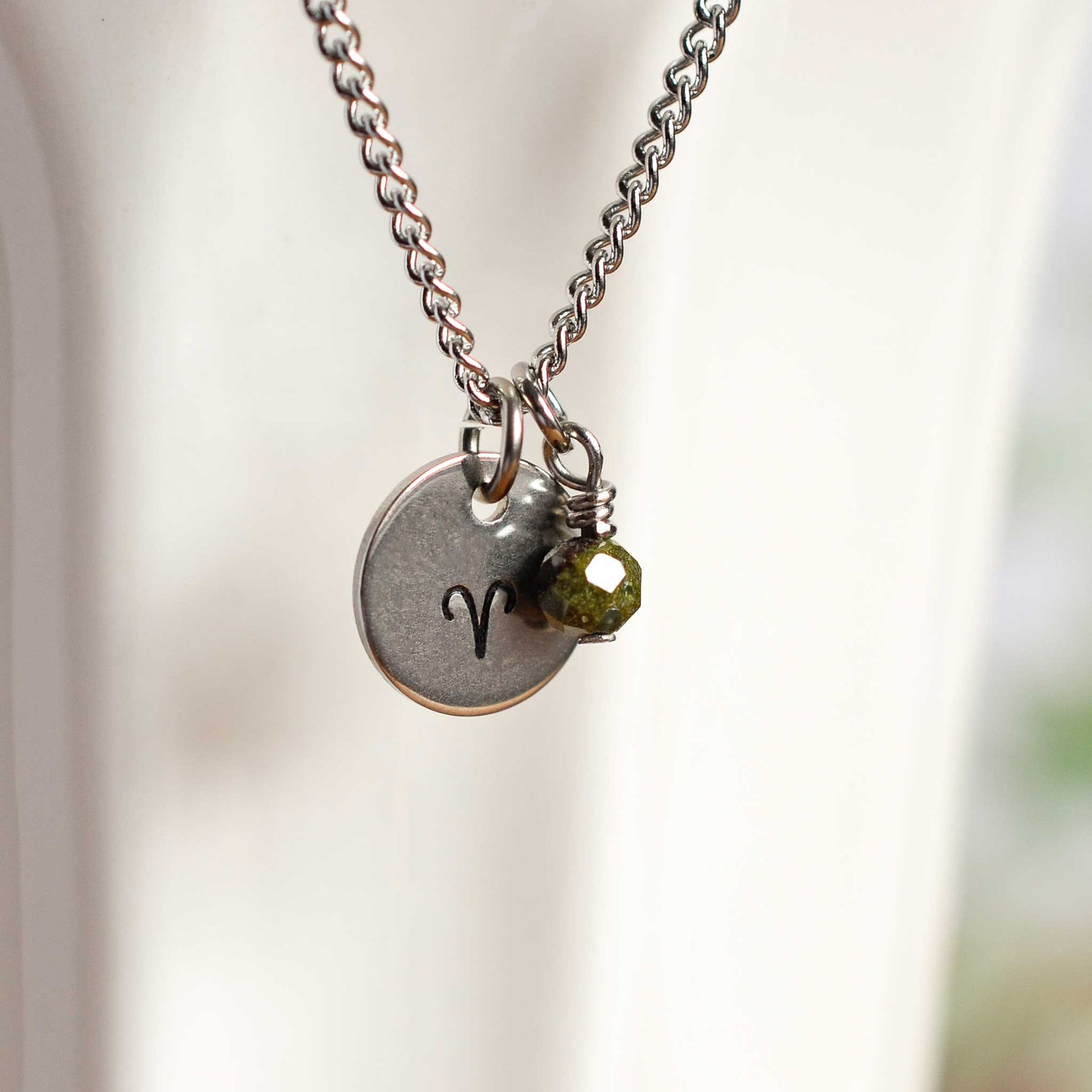 Close up of Aries zodiac sign necklace with Bloodstone gemstone charm on stainless steel chain