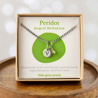 Peridot August Birthstone necklace with hand stamped initial inside an eco-friendly gift box sitting on wooden coaster