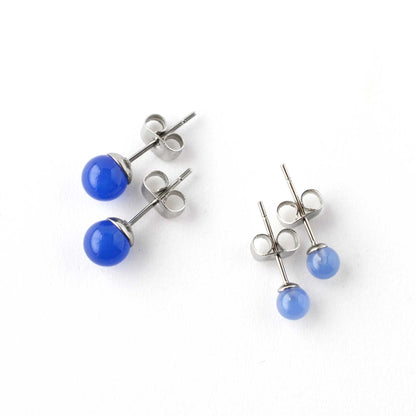 Two pairs of blue spherical earrings on a white background