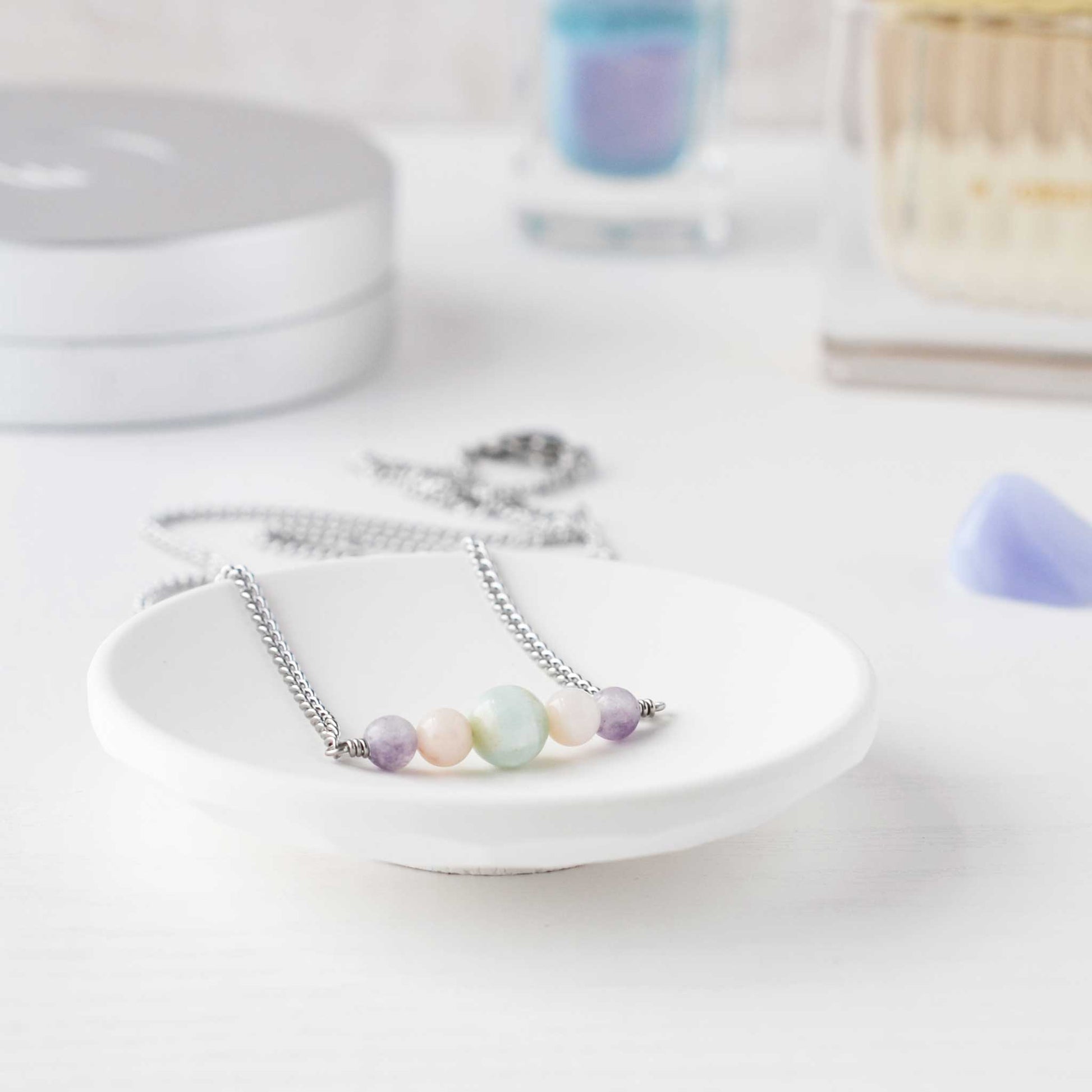 Pastel gemstone necklace in trinket dish on dressing table