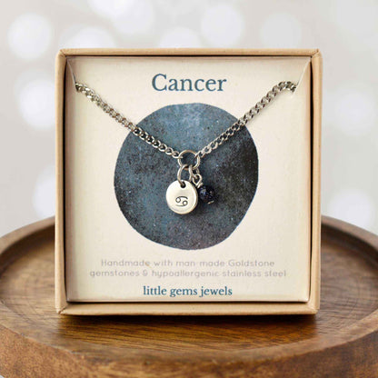 Dainty Cancer zodiac sign necklace in eco-friendly gift box on wooden coaster